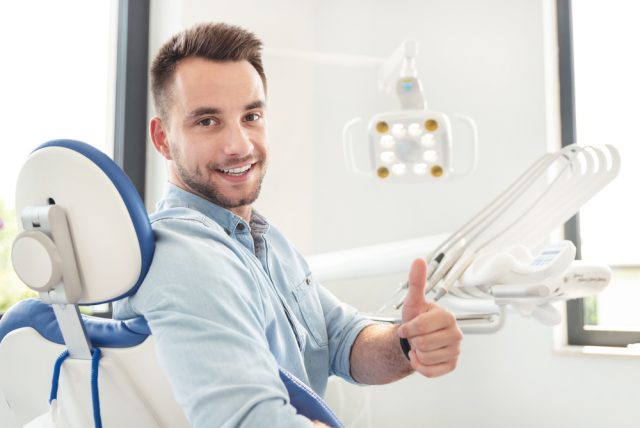 man giving thumbs up at the dentist